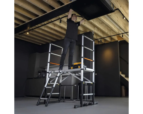 Eine Person arbeitet auf einem Gerüst an der Decke.