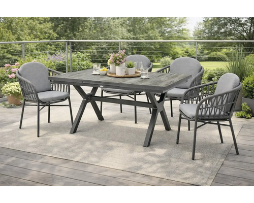 Gartentisch mit vier Stühlen auf einer Terrasse mit grauem Teppich