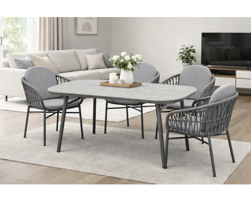 Esstischgruppe mit Tischplatte in Steinoptik und vier Stühlen mit gewebter Rückenlehne in einem hellen Wohnraum.