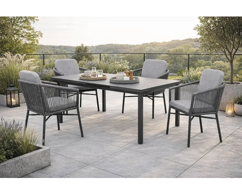 Gartenszene mit Esstisch und vier Stühlen auf einer Terrasse.