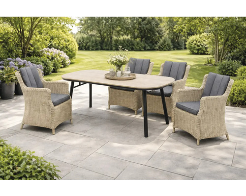 Gartenszene mit einem Esstisch und vier Korbsesseln mit Sitzkissen im Freien