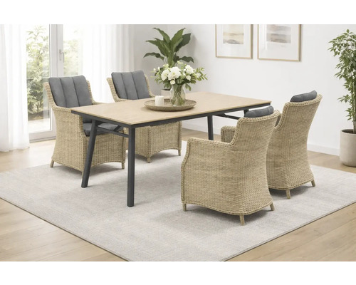 Esstisch-Set mit vier Korbsesseln und grauem Sitzkissen auf einem hellen Teppich.