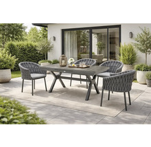 Scène de jardin avec table à manger en bois et quatre chaises avec détails tressés.