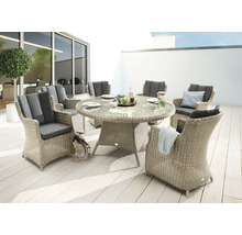 Scène de jardin avec table à manger ronde et six chaises en rotin avec coussins gris
