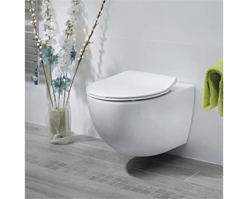 Wandhängendes WC mit WC-Sitz in einem hellen Badezimmer.