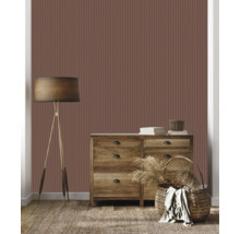 Salon avec papier peint marron à rayures verticales, commode, lampadaire et décoration