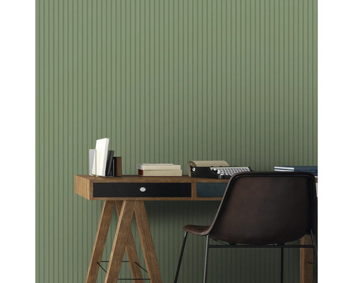 Scène avec bureau, livres, machine à écrire et chaise devant un mur à rayures.