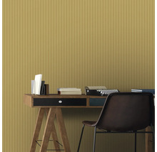 Scène avec bureau, livres, machine à écrire et chaise devant un revêtement mural jaune.