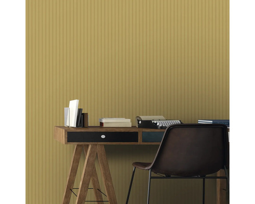 Scène avec bureau, livres, machine à écrire et chaise devant un revêtement mural jaune.