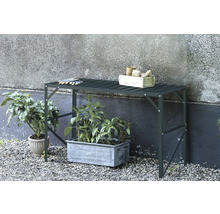 Gartentisch mit Pflanzen, Gartenwerkzeugen und Handschuhen im Aussenbereich