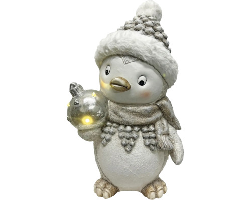 Pingouin décoratif avec bonnet, écharpe et boule de Noël lumineuse.