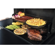 Aliments préparés sur un gril, notamment des côtes levées, des macaronis au fromage, du rôti de porc, des pizzas, des asperges, du maïs et des poivrons.