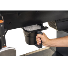 Seau de récupération des graisses sur un barbecue avec une main tenant la poignée