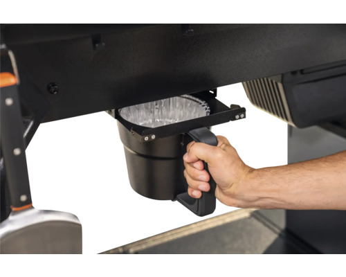 Seau de récupération des graisses sur un barbecue avec une main tenant la poignée