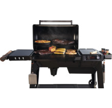 Barbecue ouvert avec des aliments tels que des épis de maïs, des travers de porc et des pizzas.