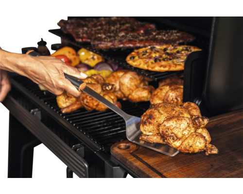 Poulet grillé retiré du barbecue avec une spatule