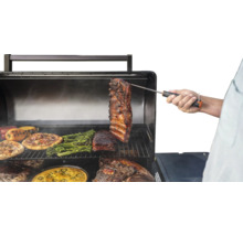 Barbecue avec pizza, poivrons, brocolis et viande, la température étant mesurée