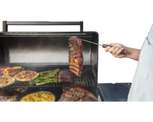 Barbecue avec pizza, poivrons, brocolis et viande, la température étant mesurée