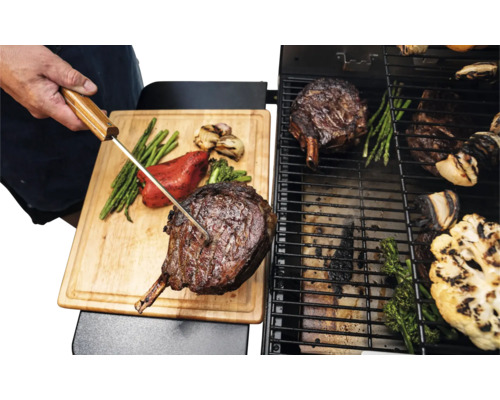 Grill avec steak Tomahawk, asperges et légumes sur grille et planche à découper