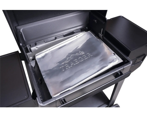Protection en aluminium Traeger pour bac à graisse insérée dans un barbecue à pellets.