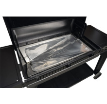 Protection de bac à graisse Traeger en aluminium insérée dans un barbecue à pellets noir.