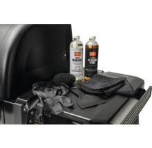 Kit de nettoyage pour barbecue Traeger avec dégraissant, spray d'entretien, grattoir, éponge, chiffon et gants sur une tablette de barbecue.
