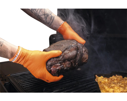 Mains avec gants en nitrile orange tenant un morceau de viande au-dessus d'un barbecue.