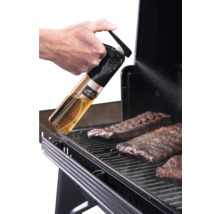 Main vaporisant de l'huile sur de la viande sur un barbecue avec un vaporisateur Traeger. Traeger Logo.