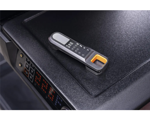 Thermomètre à viande numérique avec tableau de température sur la surface d'un barbecue.