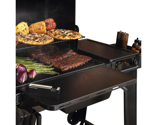 Offener Pelletgrill mit Rippchen, Spargel, Paprika, Zwiebeln und Pizzen auf den Grillrosten, inklusive digitaler Steuerung und Seitenablage.