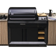 Eingebauter Traeger Timberline Pelletgrill in einer Außenküche mit schwarzem Gehäuse, Holzregalen und digitalem Display.