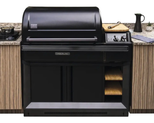 Eingebauter Traeger Timberline Pelletgrill in einer Außenküche mit schwarzem Gehäuse, Holzregalen und digitalem Display.