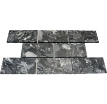 Carreaux en pierre naturelle en pose décalée, granit noir et gris avec veinage marqué et inclusions claires.