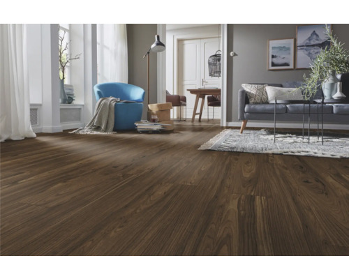 Moderner Wohnbereich mit dunklem Laminatboden in Holzoptik, blauem Sessel, grauem Sofa und hellem Teppich.