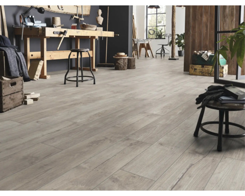 Bodenbelag in grauer Holzoptik in einer hellen Werkstatt mit Werkbank aus Holz und Hockern.