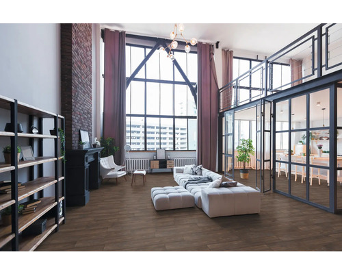 Geräumiges Loft-Wohnzimmer im Industriestil mit Boden in Holzoptik, großer Fensterfront, Backsteinwand und modernen Möbeln.