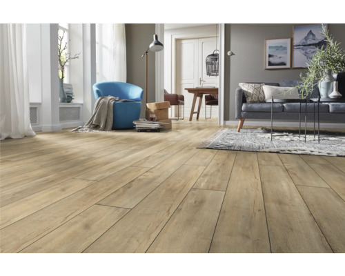 Laminatboden in Eichenoptik in einem hellen, modernen Wohnzimmer mit Sofa, blauem Sessel und Teppich.