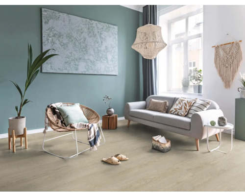 Helles Wohnzimmer mit Boden in Holzoptik, grauem Sofa, Korb-Sessel, großer Hängeleuchte und Wanddekoration im Boho-Stil.