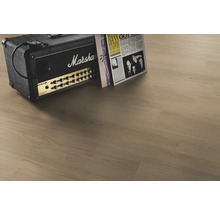 Laminatboden in heller Eichenoptik mit authentischer Holzmaserung, kombiniert mit einem Gitarrenverstärker mit Marshall Logo und Schallplatten.