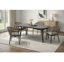 Ensemble de salle à manger moderne avec table sombre et quatre chaises tressées sur un tapis clair dans une pièce lumineuse et ordonnée.