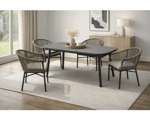 Ensemble de salle à manger moderne avec table sombre et quatre chaises tressées sur un tapis clair dans une pièce lumineuse et ordonnée.