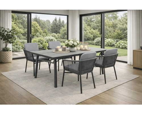 Moderner Essbereich mit rechteckigem Tisch und vier Gartenstühlen mit Seilbespannung und Kissen auf einem Teppich vor grossen Fensterfronten.
