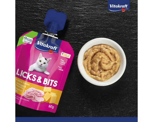 Snack pour chat Vitakraft Licks et Bits au fromage et au jambon, sachet de 60 grammes sans sucre ajouté ni céréales, et bol avec snack crémeux.