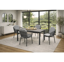 Modernes Essgruppenset mit rechteckigem Tisch und vier Stühlen mit grauen Polstern und Flechtoptik in einem hellen Raum mit Gartenblick.