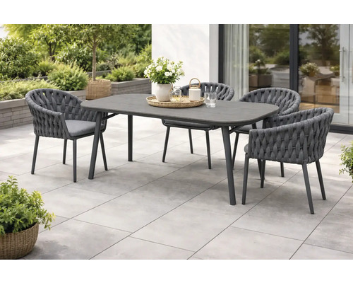 Modernes Gartenmöbel-Set bestehend aus einem grauen Esstisch und vier geflochtenen Armlehnstühlen mit Sitzkissen auf einer hellen Steinterrasse.