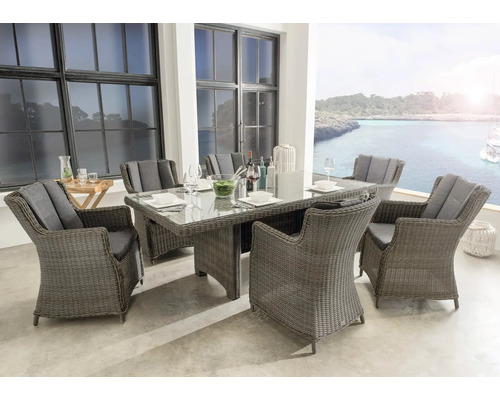 Salon de jardin en polyrotin avec six chaises à dossier haut et une grande table avec plateau en verre sur une terrasse.