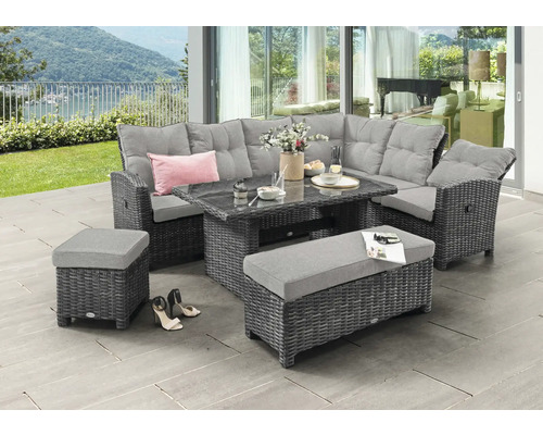 Salon de jardin en polyrotin gris avec canapé de coin, table en verre, banc et tabouret sur une terrasse lumineuse avec vue sur la nature.