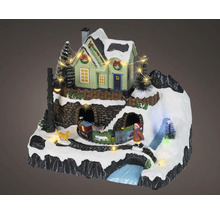 Paysage de Noël miniature avec maison éclairée, train, enfant, chien et décor de montagne enneigé.