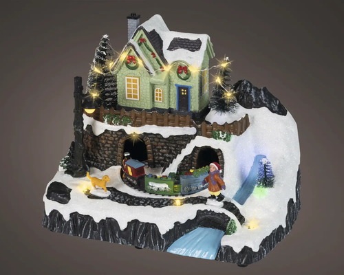 Paysage de Noël miniature avec maison éclairée, train, enfant, chien et décor de montagne enneigé.