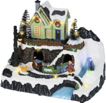 Village de Noël animé avec montagne enneigée, maison illuminée, train en mouvement, figurines et éclairage LED.